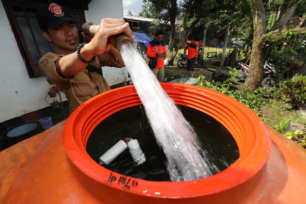 Petugas BNPB mengalirkan air bersih untuk para pengungsi/BNPB