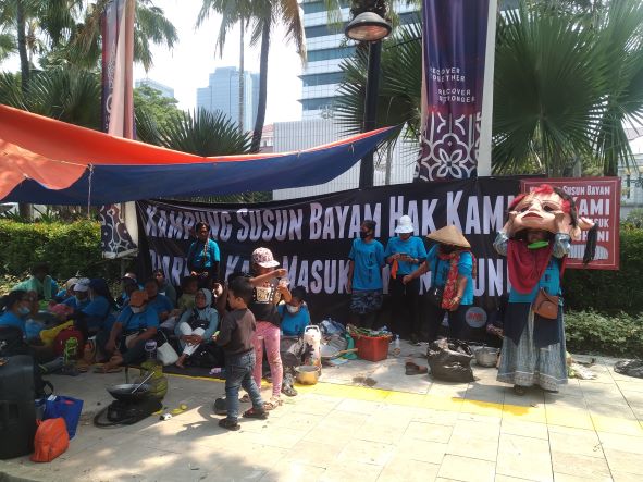 Warga Kampung Bayam menggelar aksi unjuk rasa di depan Gedung Balai Kota Jakarta. (SinPo.id/Zikri Maulana)