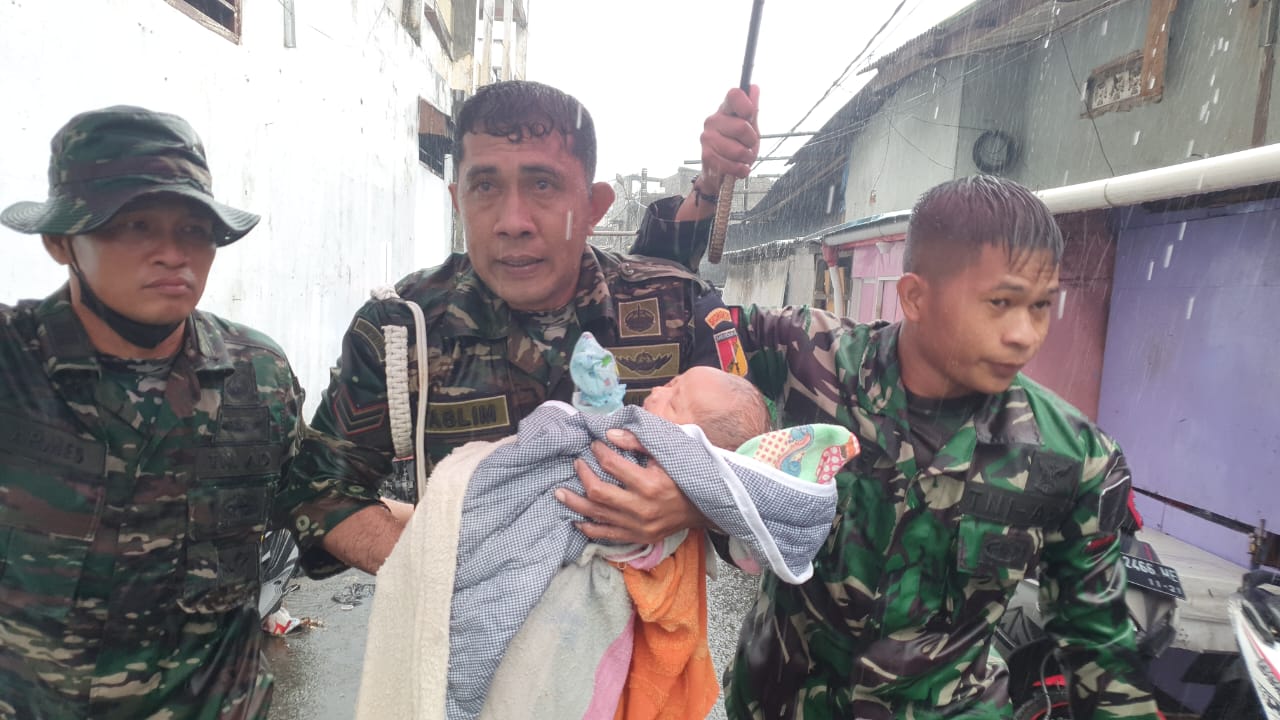 Personel TNI AD menggendong bayi korban bencana banjir di Manado/Puspen TNI