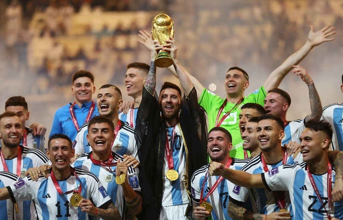 Kapten Timnas Argentina Lionel Messi mengangkat trofi Piala Dunia bersama rekan satu timnya saat mereka merayakan kemenangan Piala Dunia 2022. (SinPo.id/Reuters)