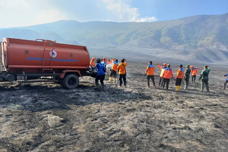 Petugas gabungan melakukan pendinginan dengan menggunakan truk tangki air untuk menyiram bekas karhutla di kawasan Gunung Bromo pada Senin, 11 September2023. (SinPo.id/BPBD Probolinggo)