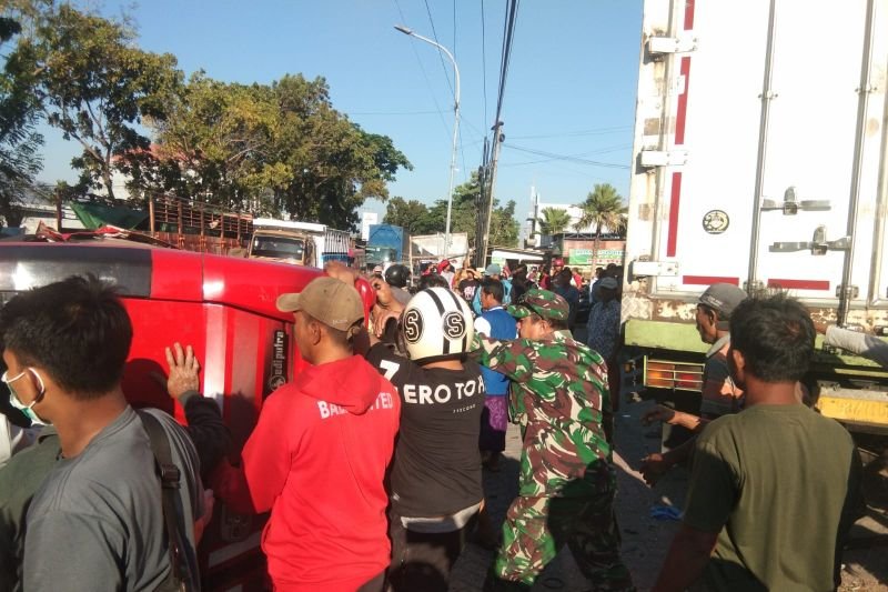 Petugas kepolisian dan TNI serta warga bergotong royong evakuasi microbus yang terguling di jalan raya pantura Kecamatan Besuki, Situbondo, Jawa Timur pada Sabtu, 23 September 2023.