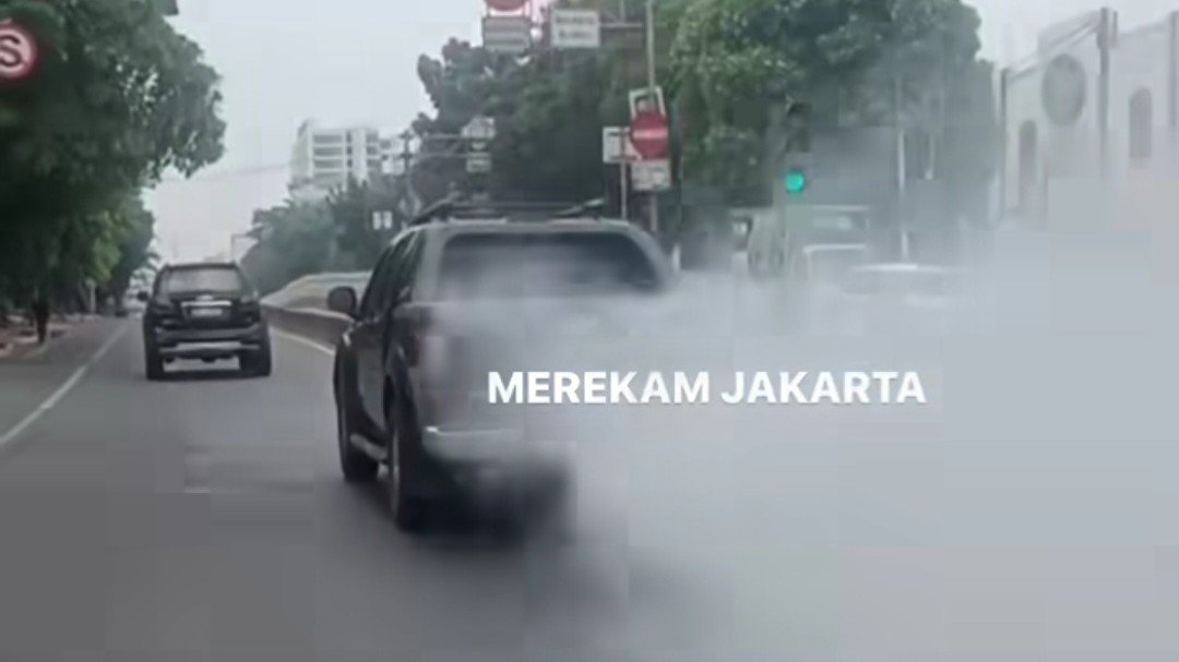 Mobil pelat merah berasap di jalan Jakarta (SinPo.id/ Tangkapan layar Instagram @merekamjakarta)
