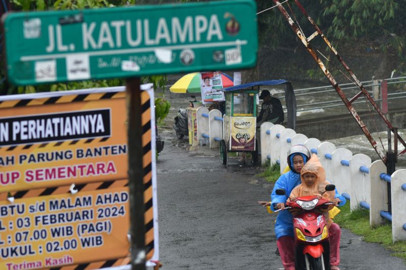 Pengendara sepeda motor memakai jas hujan melintas di Jalan Katulampa, Kota Bogor, Jawa Barat. (SinPo.id/Antara)