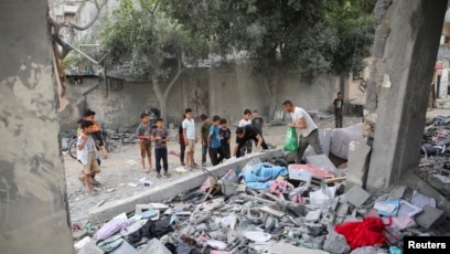 Warga Palestina memeriksa lokasi serangan Israel di sebuah rumah di Rafah, di Jalur Gaza (SinPo.id/Reutres)