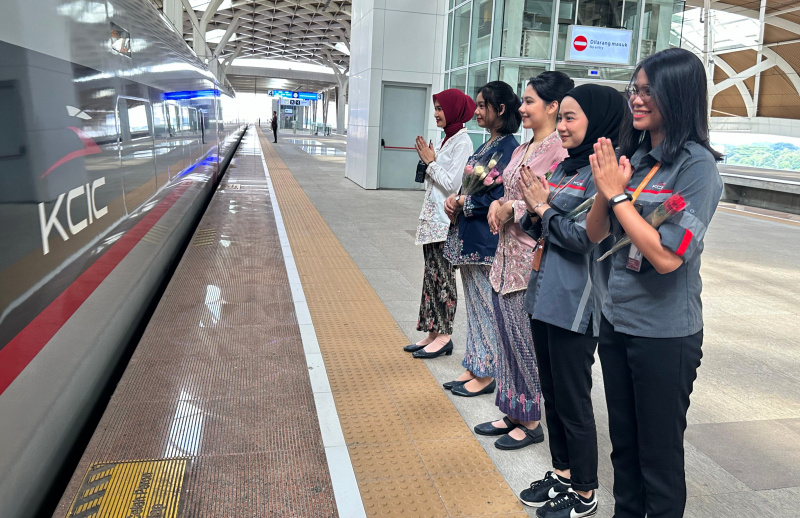Petugas Passenger Service KCIC membagikan 150 bunga pada penumpang perempuan di Hari Kartini di Stasiun Halim KCIC (Ashar/SinPo.id)