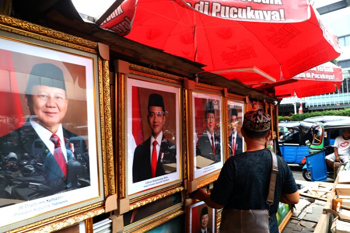 Pedagang menjajakan foto Prabowo-Gibran sebagai Presiden dan Wakil Presiden RI (SinPo.id/Ashar)