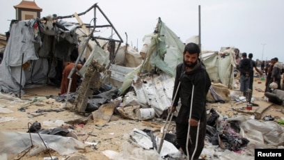 Masyarakat Palestina memeriksa puing-puing tenda yang hancur akibat serangan udara Israel (SinPo.id/ Reuters)