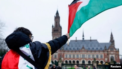 Seorang pria mengibarkan bendera Palestina (SinPo.id/Reutres)