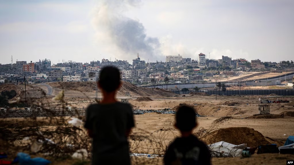 Anak laki-laki menyaksikan kepulan asap di tengah serangan Israel di timur Rafah di Jalur Gaza selatan pada 13 Mei 2024. (SinPo.id/ AFP)