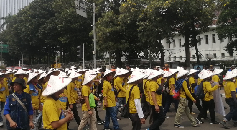 Massa memakai caping dalam unjuk rasa May Day 2024 di Patung Kuda (SinPo.id/ Tio Pirnando)