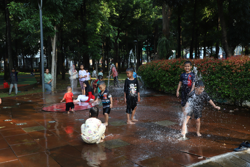 Warga Jakarta sedang menikmati liburan akhir pekan di RPTRA Taman Puring dengan Keluarga dan Anaknya bermain mandi Air Mancur (Ashar/SinPo.id)