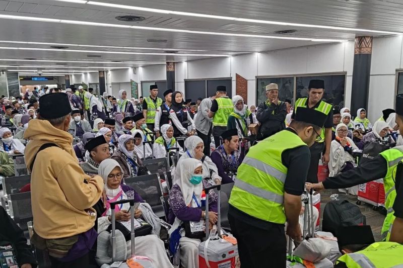 Petugas saat mengatur para jamaah haji Indonesia kloter pertama pemberangkatan ke Mekah melalui Bandara Internasional Soekarno-Hatta, Tangerang. (SinPo.id/Antara)