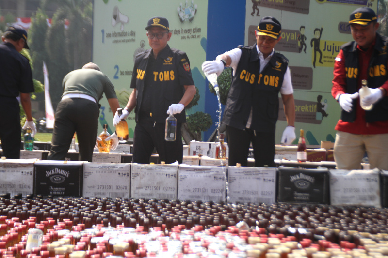 Petugas Bea Cukai musnahkan ratusan ribu botol miras dan rokok ilegal senilai Rp 165 miliar (SinPo.id/Ashar)