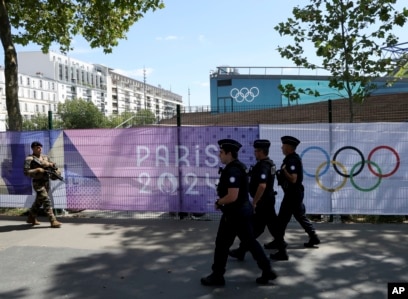 polisi berpatroli di dekat spanduk Olimpiade Paris 2024 di Paris (SinPo.id/AP)