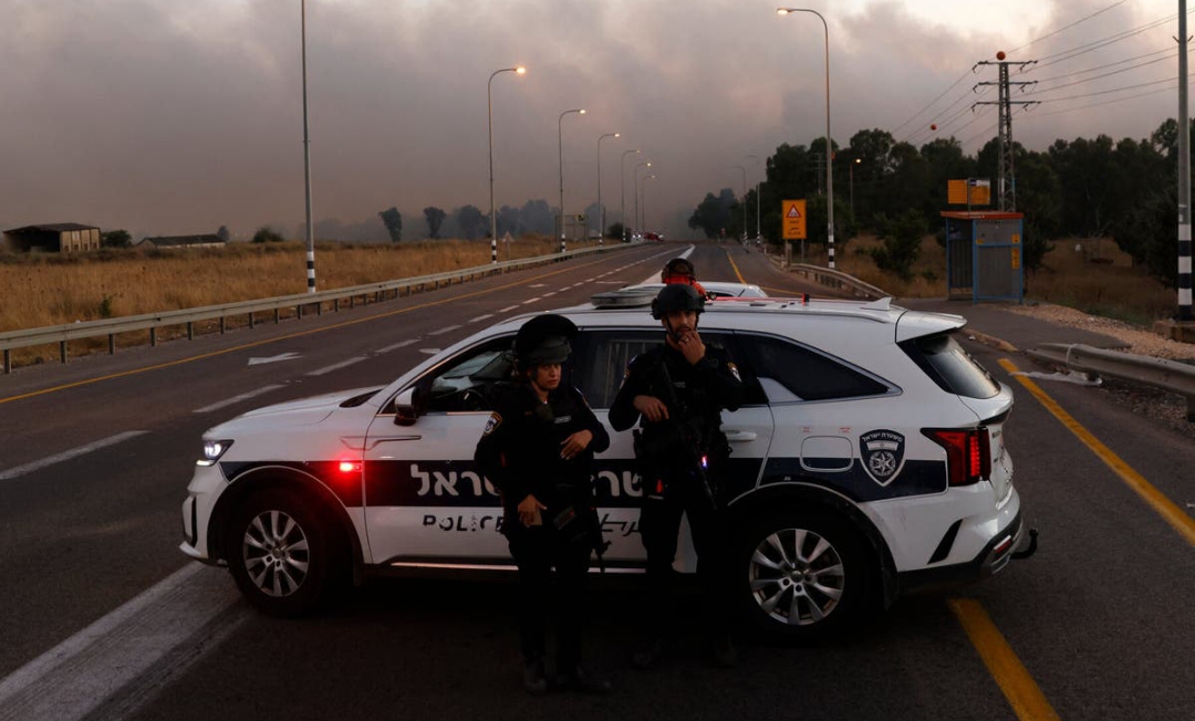 Polisi Israel mengamankan jalanan di Golan Heights dekat perbatasan, setelah Hizbullah meluncurkan serangan roket (SinPo.id/ Getty Images)