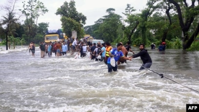 Warga berjalan di tengah banjir di Feni, 22 Agustus 2024. (SinPo.id/AFP)