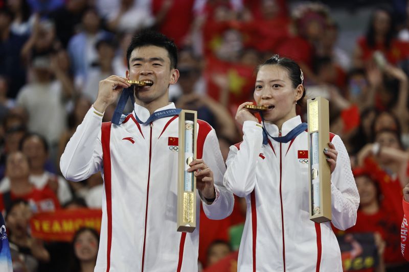 Pasangan ganda campuran China Zheng Si Wei/Huang Ya Qiong berfoto di atas podium setelah memenangkan medali emas Olimpiade Paris 2024. (SinPo.id/AFP)