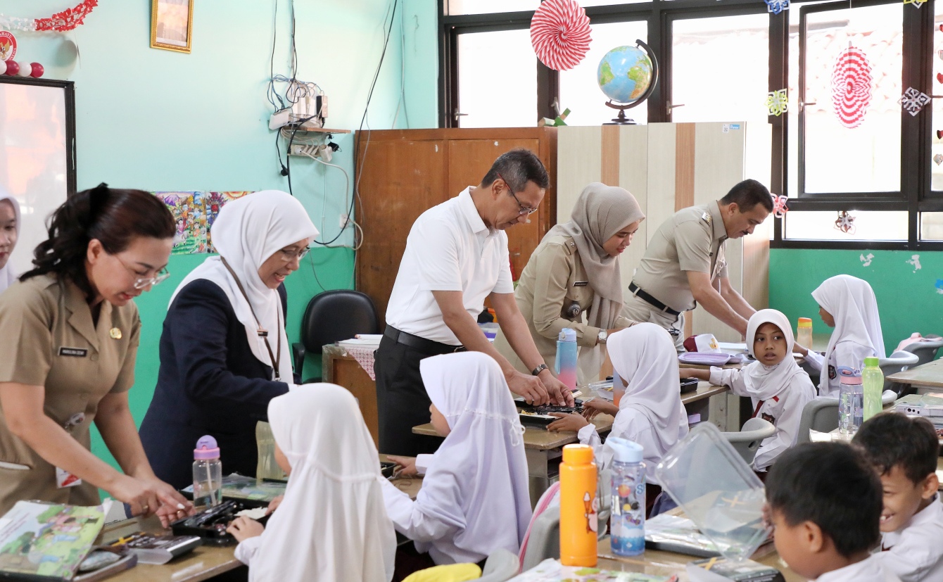 Pj Gubernur DKI Heru Budi Hartono saat melakukan uji coba makan bergizi gratis (SinPo.id/ Pemprov DKI)