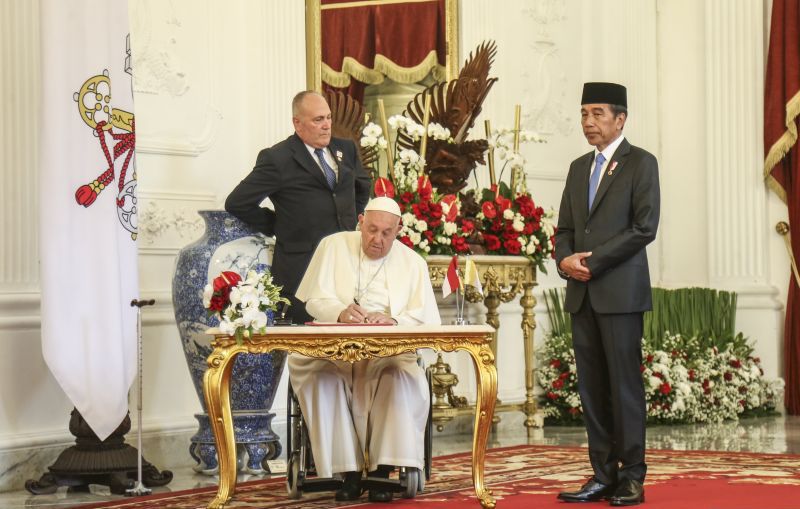 Presiden Jokowi menyaksikan Pemimpin Takhta Suci Vatikan Sri Paus Fransiskus (kedua kiri) mengisi buku tamu sebelum melakukan pertemuan di Istana Merdeka. (SinPo.id/Antara)