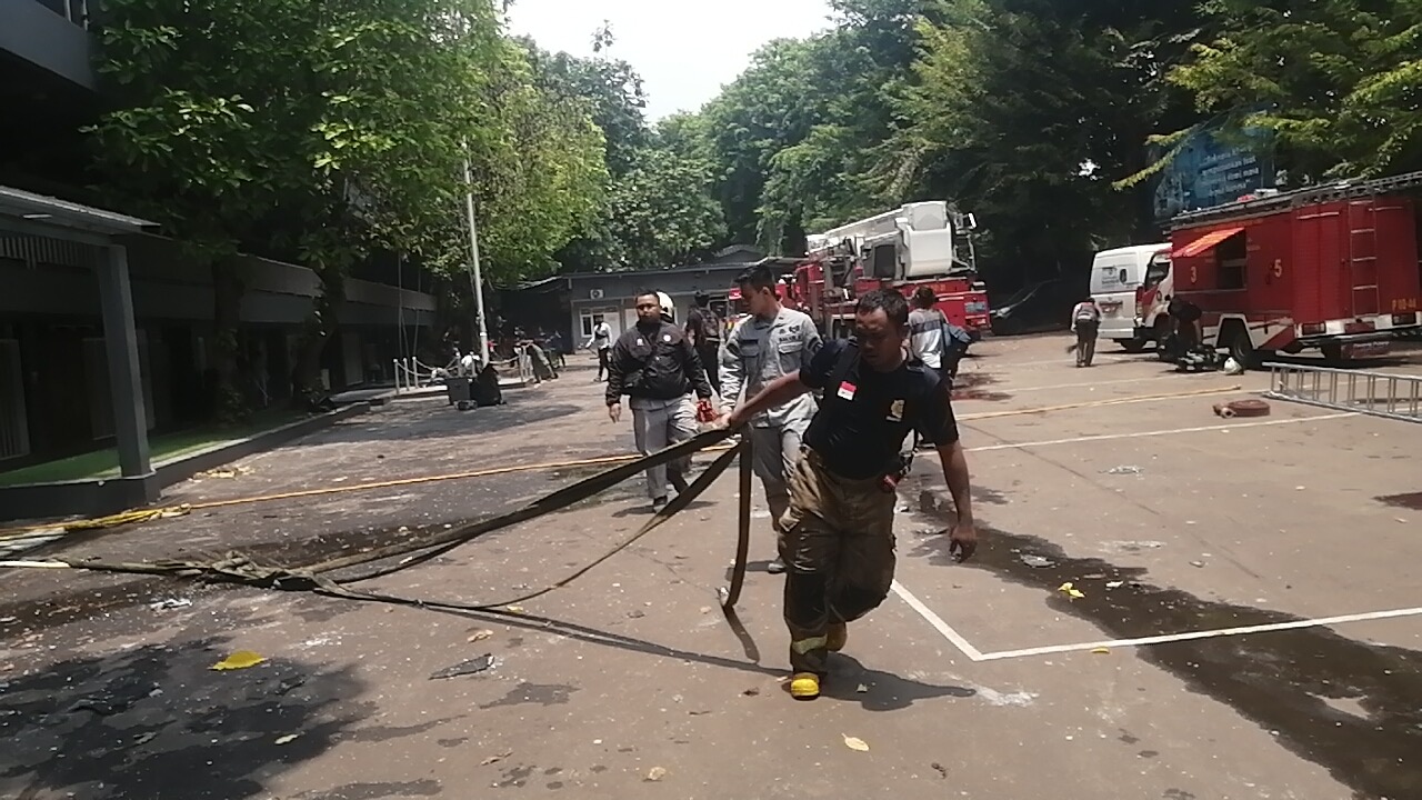 Petugas Damkar melakukan pemadaman api di Gedung Bakamla RI. (SinPo.id/Tio)