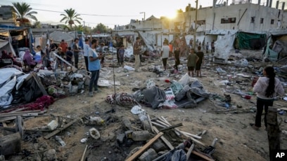 Warga Palestina melihat kerusakan di area tenda di halaman rumah sakit Al Aqsa Martyrs, yang terkena serangan udara Israel di Jalur Gaza (SinPo.id/AP)