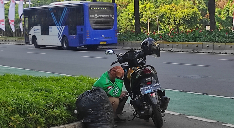 Pengemudi ojol terlihat sedang kelelahan (SinPo.id/ Ashar)