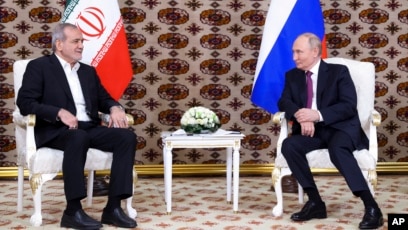 Presiden Rusia Vladimir Putin, kanan, mendengarkan Presiden Iran Masoud Pezeshkian selama pertemuan mereka (SinPo.id/AP)