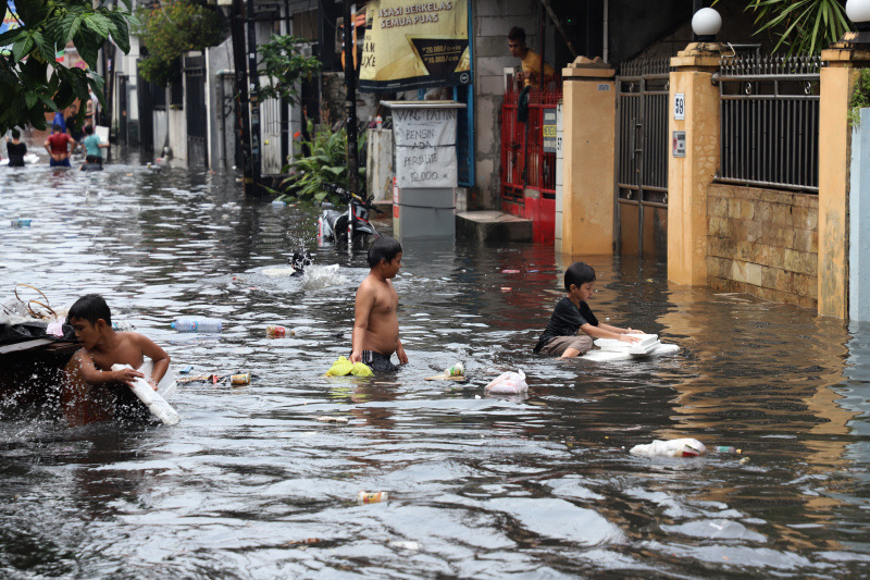 Ilustrasi anak-anak bermain di lokasi banjir  Jalan Adam, Rawa Belong. (SinPo.id/Ashar)