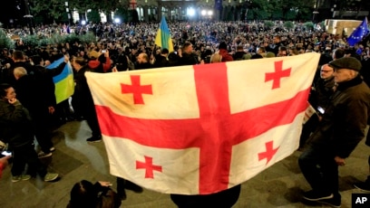 Para pengunjuk rasa memegang bendera Georgia (SinPo.id/AP)