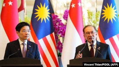 Perdana Menteri Malaysia Anwar Ibrahim (kanan) dan Perdana Menteri Singapura Lawrence Wong (kiri) (SinPo.id/AFP)