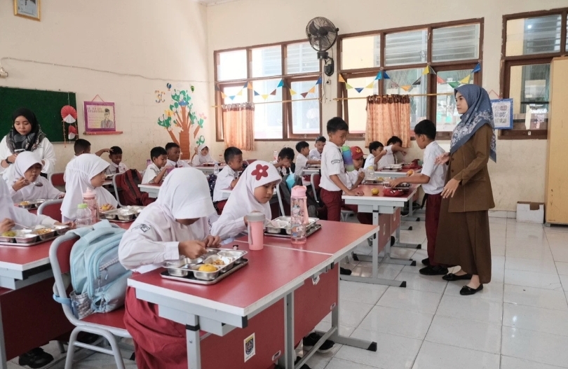 Anak-anak SDN Cilangkap 05 Tapos menyantap makan bergizi gratis (SinPo.id)