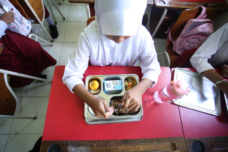 Ilustrasi penyaluran makan bergizi gratis ke siswa-siswi sekolah dasar (SinPo.id/ Ashar)