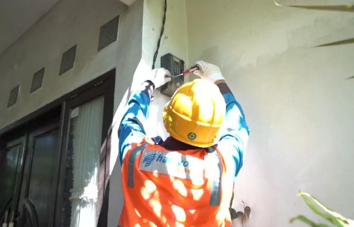 Petugas PLN saat melakukan penambahan daya pada kWh meter (SinPo.id/dok.PLN)