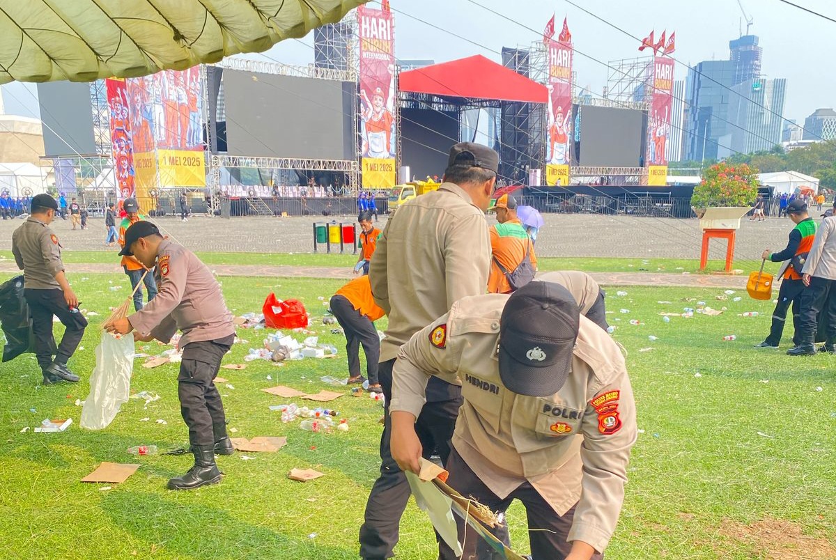Anggota polisi bersihkan sampah di kawasan Monas (SinPo.id/ Humas Polres Jakpus)