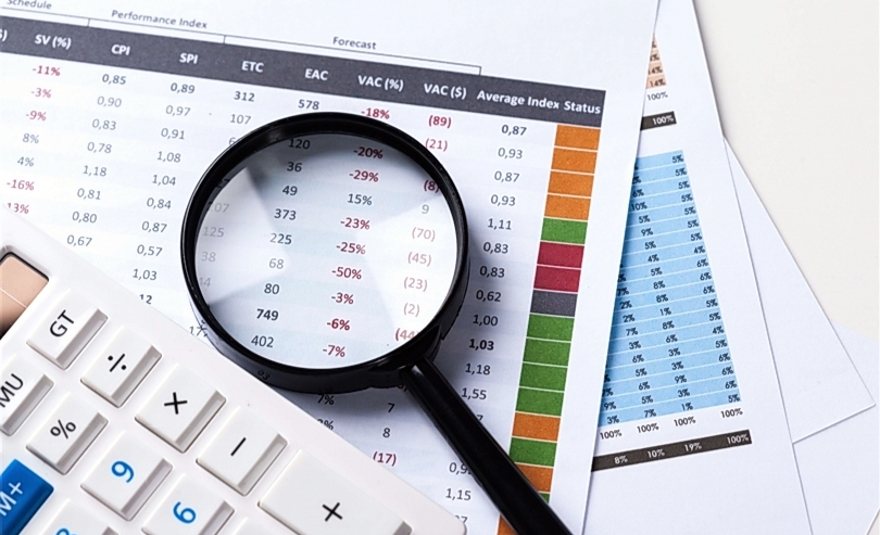 Ilustrasi kalkulator, kaca pembesar di atas tumpukan laporan keuangan. (SinPo.id/ Freepik)