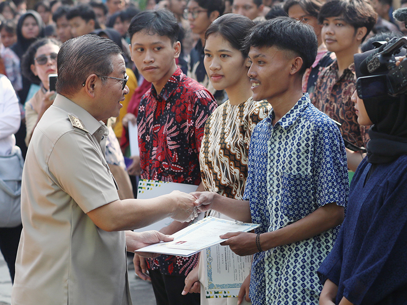 Pramono Anung serahkan menyerahkan bantuan pemutihan ijazah tahap III tahun 2025 (SinPo.id/Beritajakarta)
