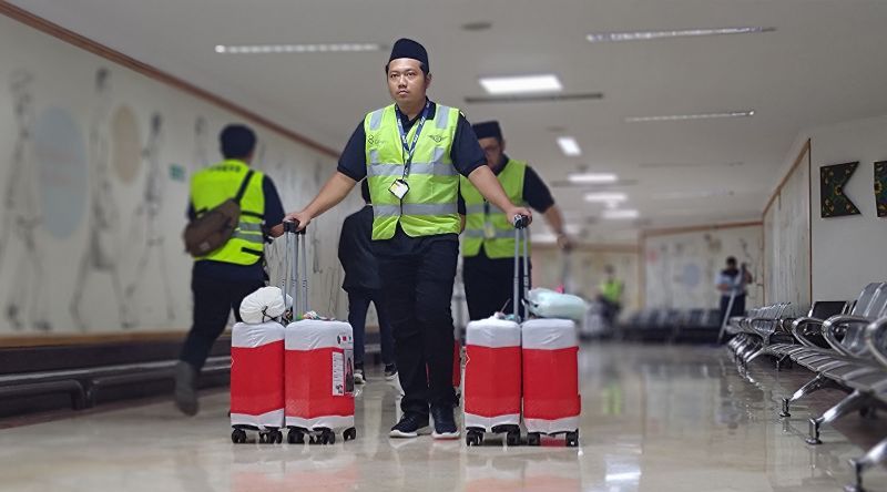 Sejumlah petugas saat membawa barang bawaan jamaah haji untuk menuju pengangkut bagasi di bandara. (SinPo.id/Dok. Angkasa Pura)