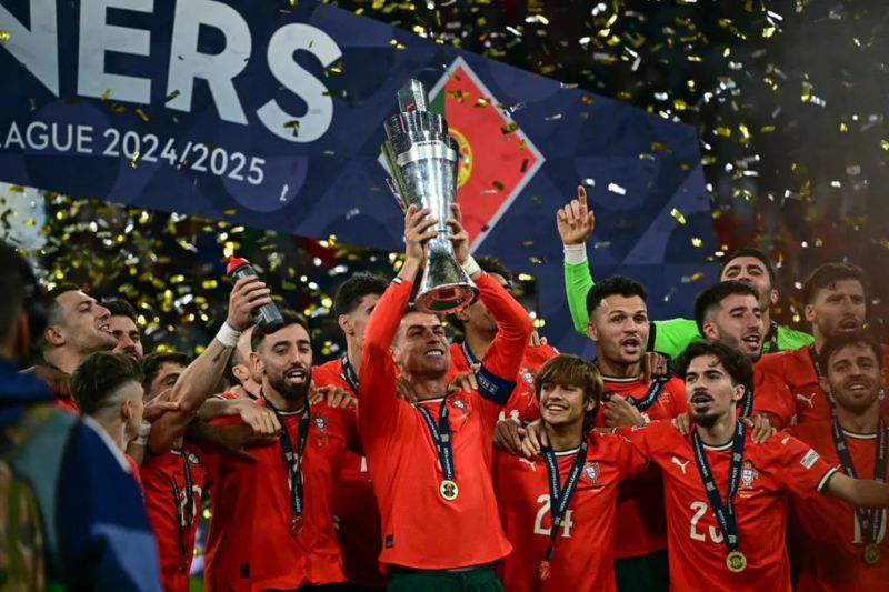 Kapten Timnas Portugal Cristiano Ronaldo (tengah) mengangkat trofi UEFA Nations League setelah menjadi juara dengan mengalahkan Timnas Spanyol di final. (SinPo.id/UEFA.com)