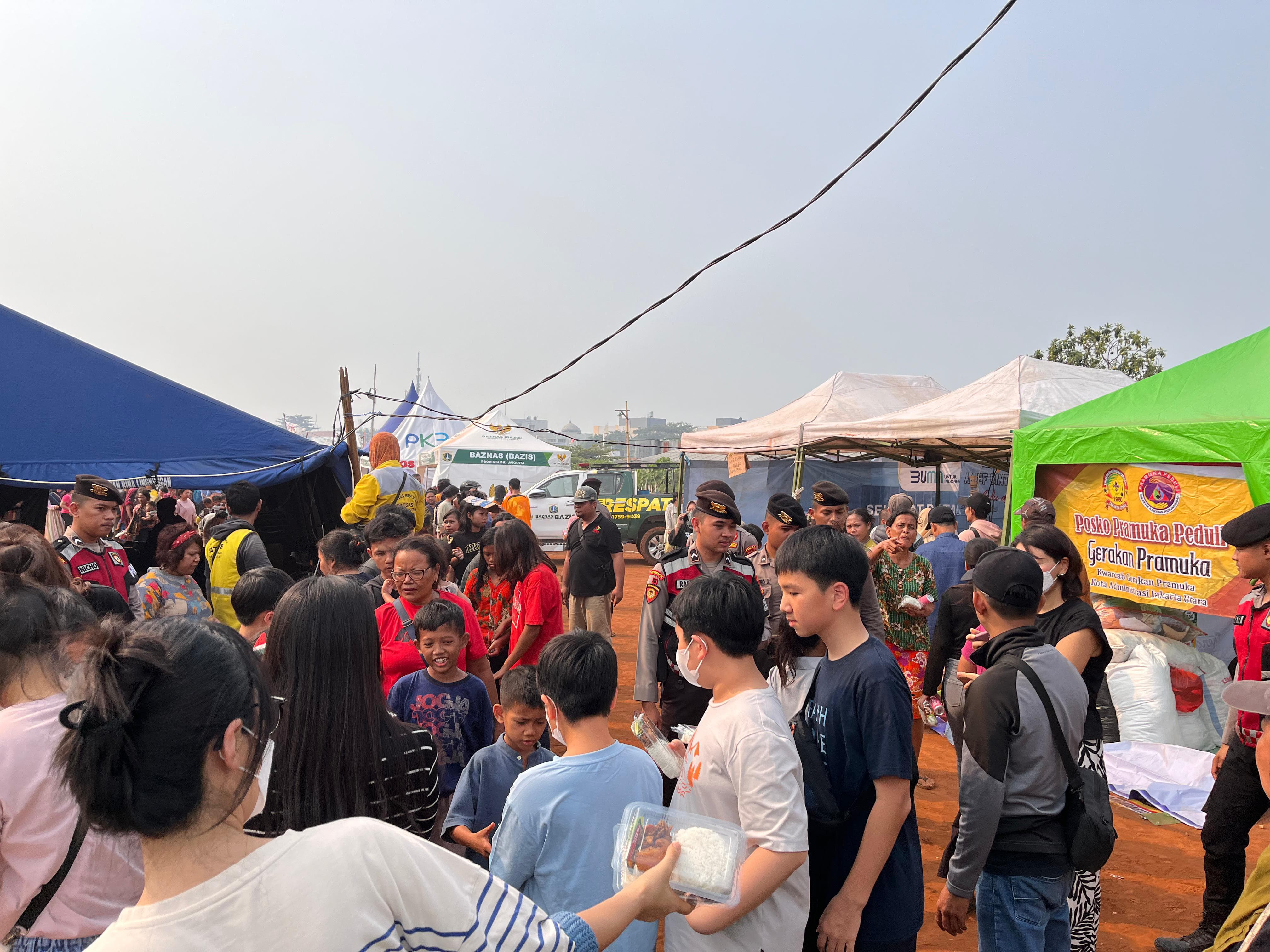 Personel Polda Metro Jaya mengawal distribusi bantuan ke korban kebakaran Jakut (SinPo.id/Dok.PMJ)