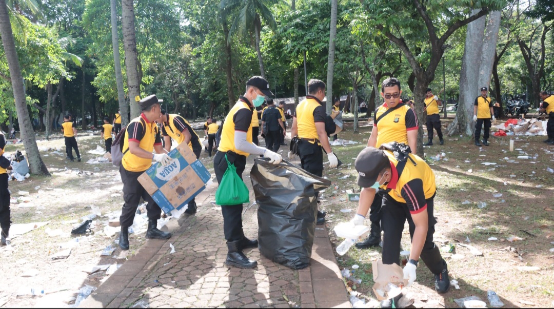 Anggota Polri saat membersihkan sampah di kawasan Monas (SinPo.id/Dok.Polres Jakpus)
