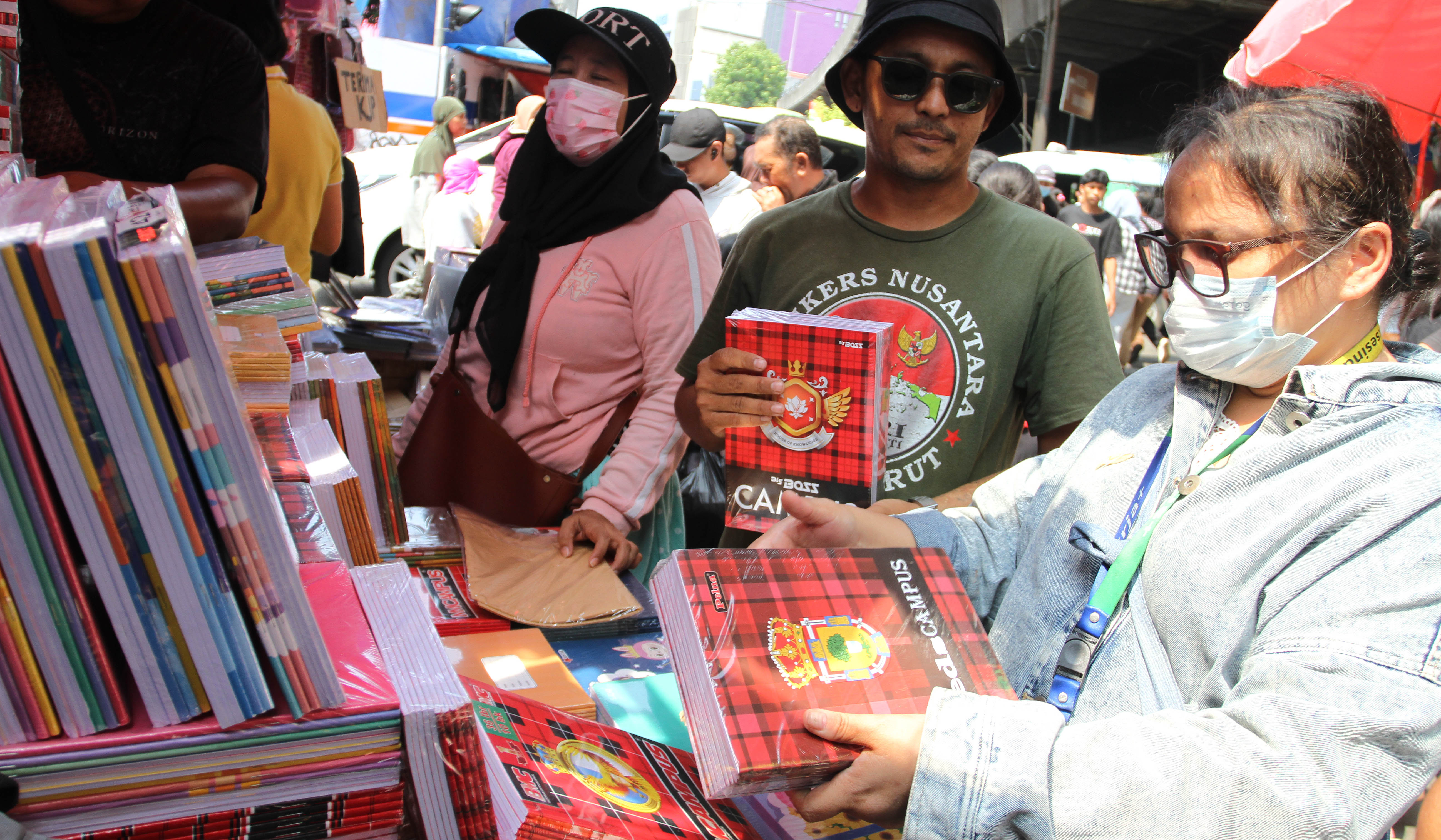 Pengunjung melihat buku tulis yang dijual di pasar pagi Asemka, Jakarta. (Agus Priatna/SinPo.id)