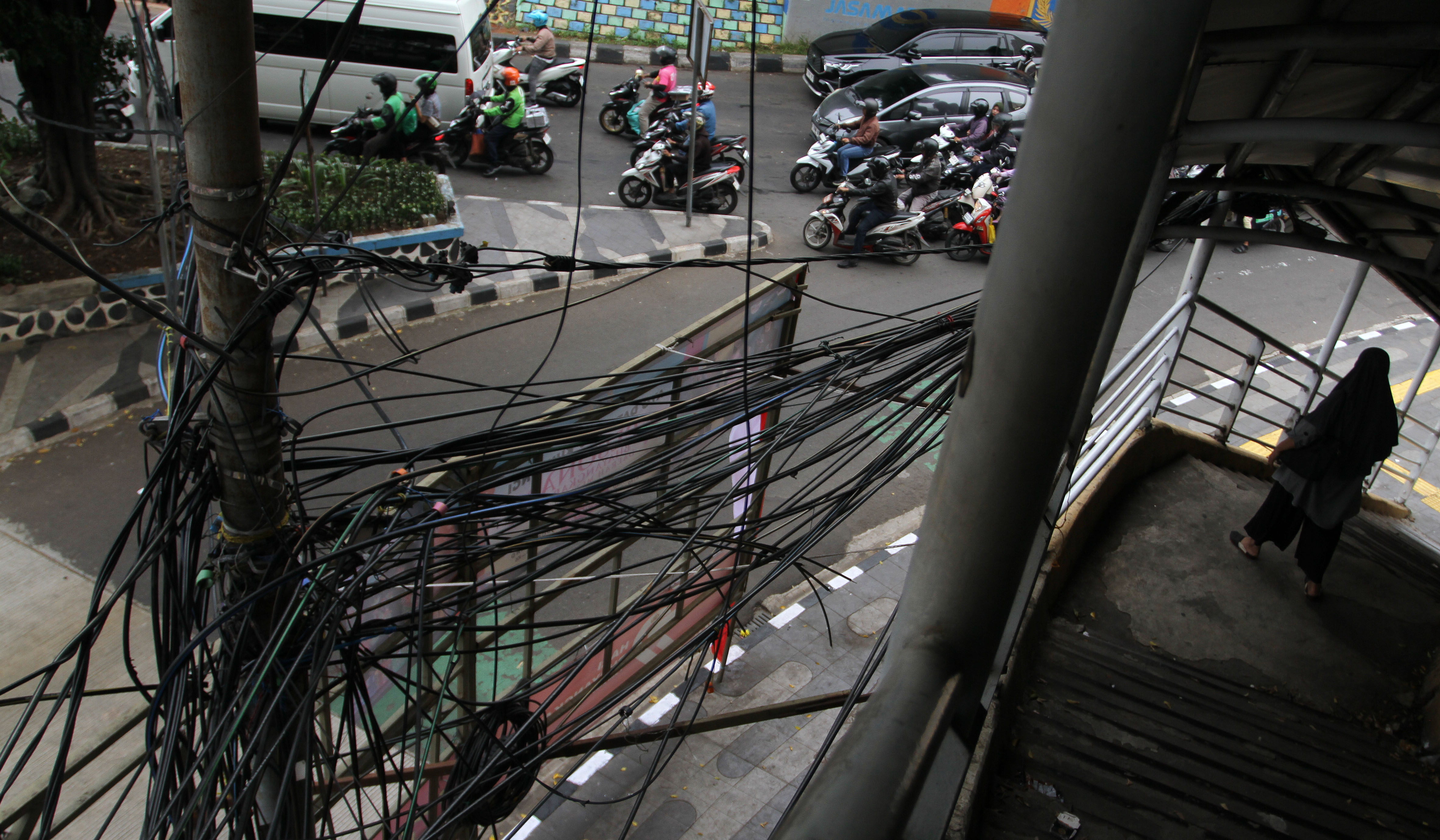 Kondisi kabel semrawut di JPO Otista, Jakarta. (Agus Priatna/SinPo.id)