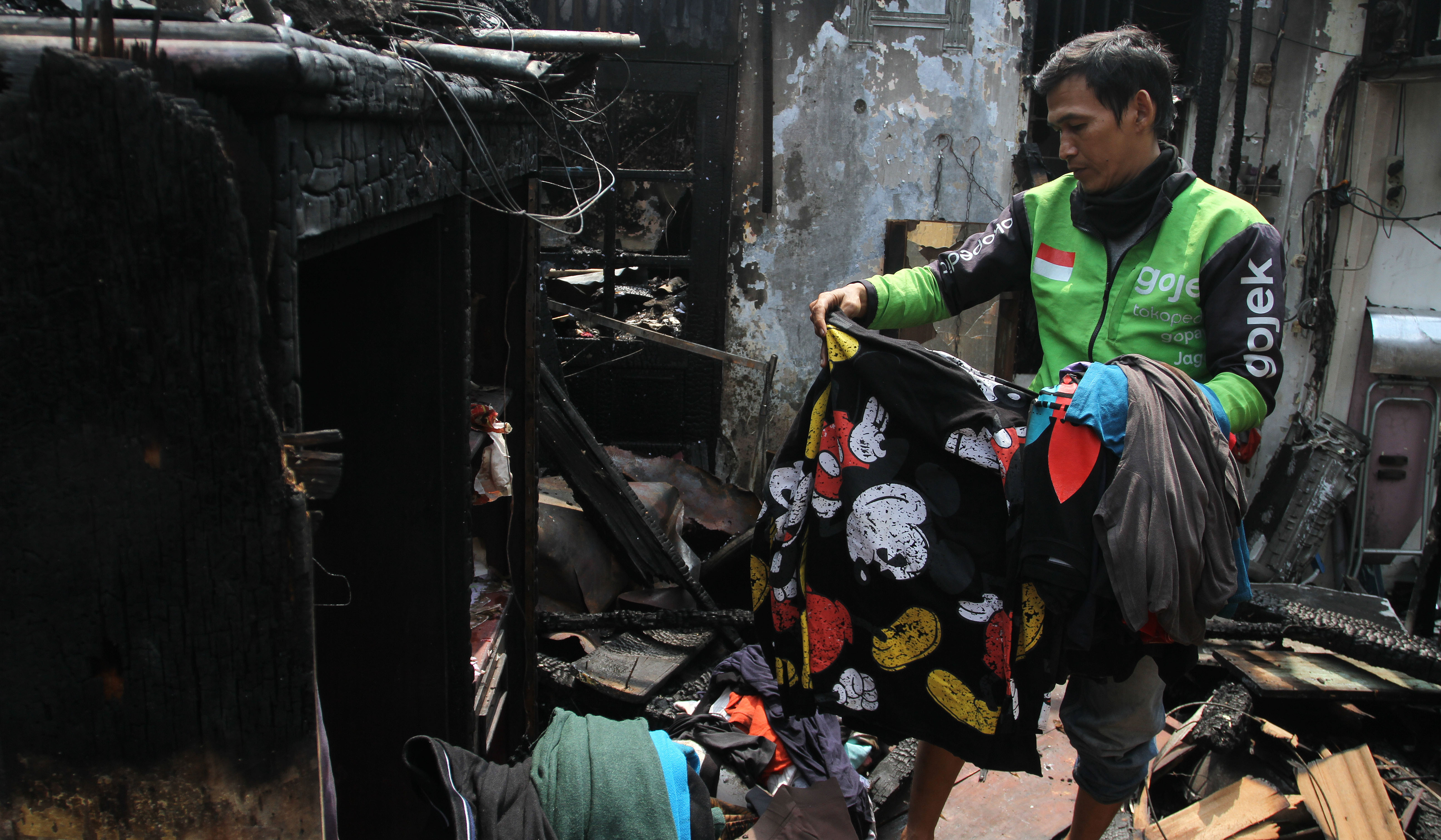 Warga mencari baju layak pakai dilokasi kebakaran. (Agus Priatna/SinPo.id)