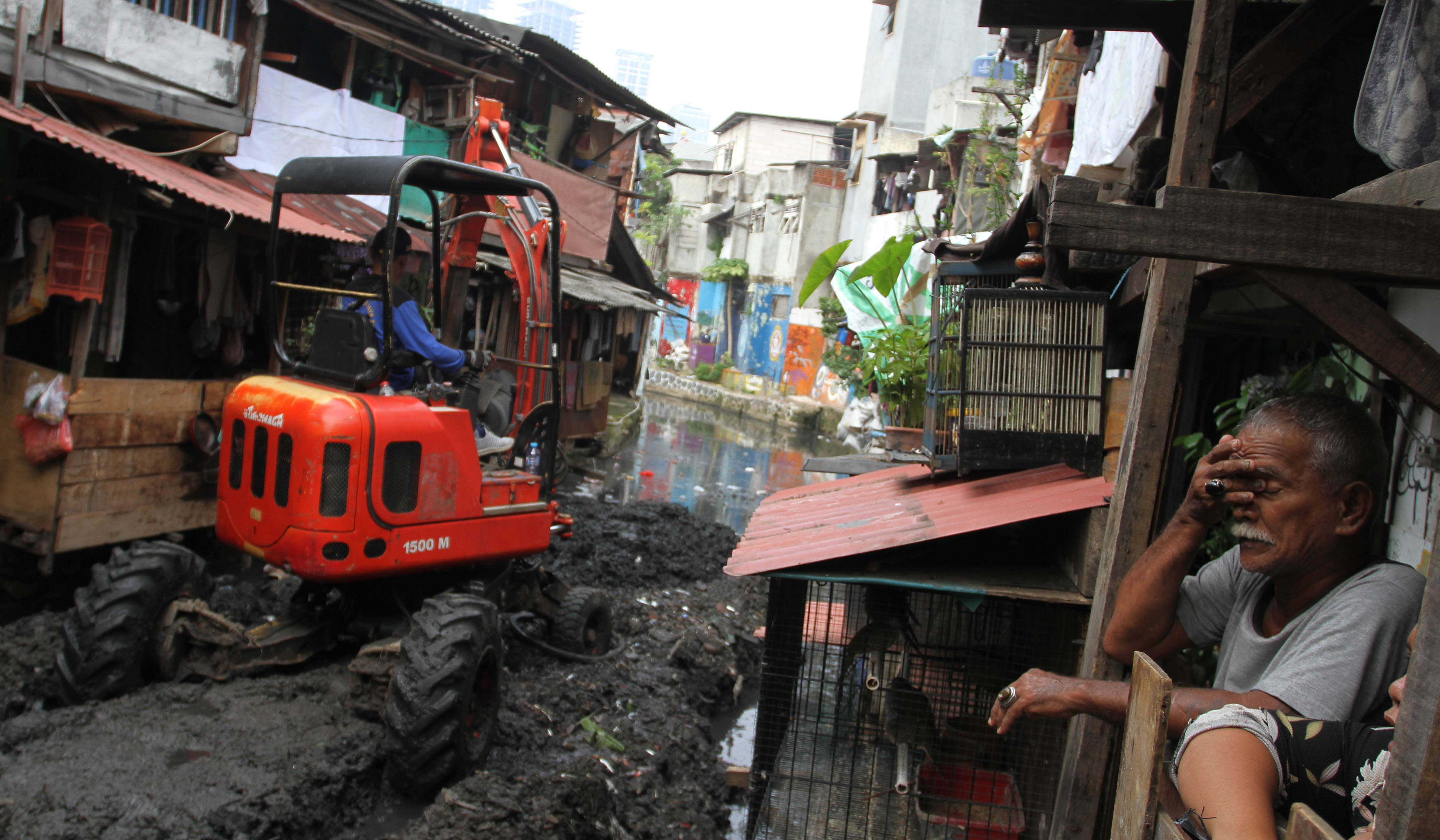 Petugas keruk lumpur kali Krukut. (Agus Priatna/SinPo.id)
