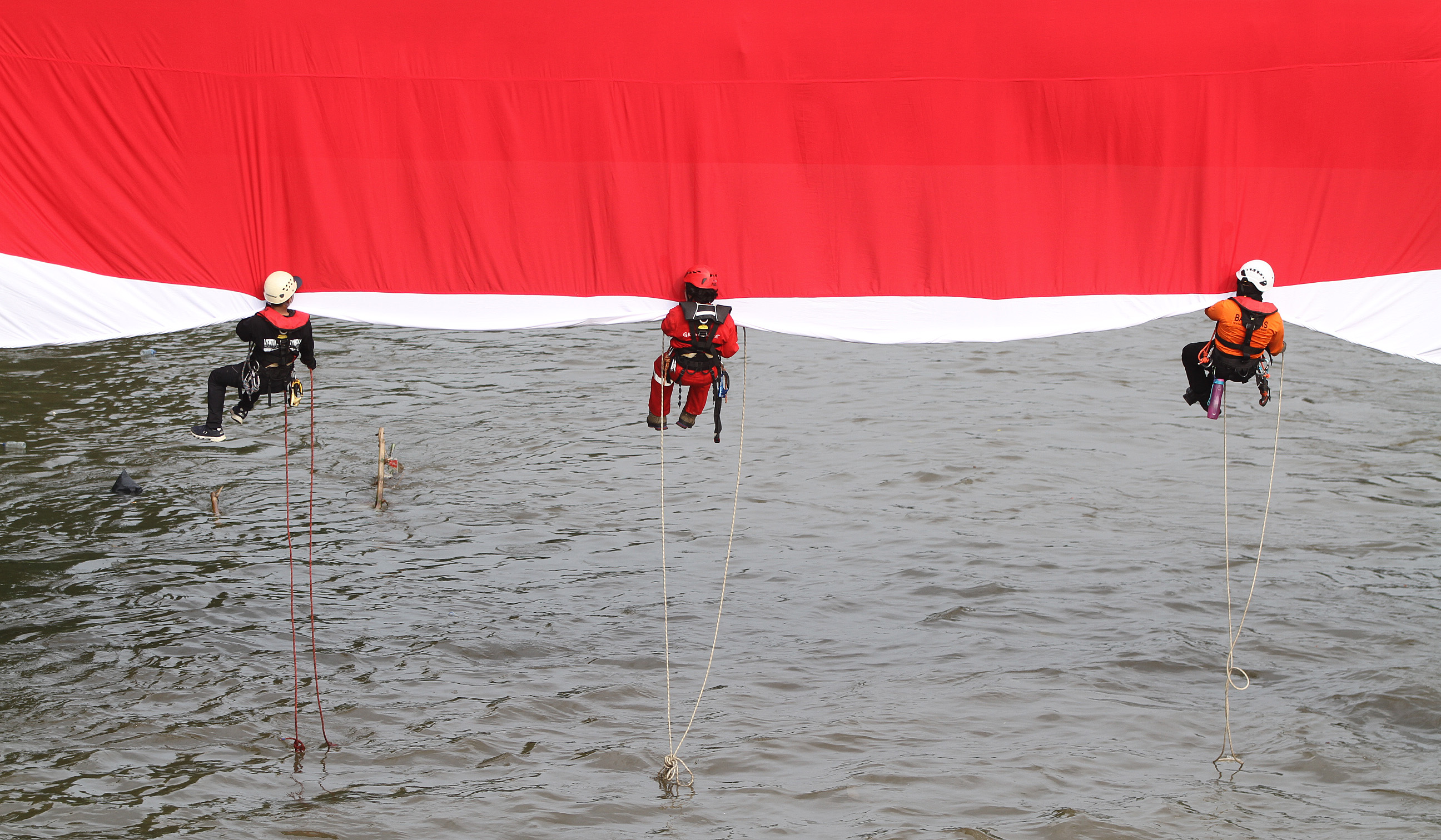 Bendera Merah Putih di Sungai Ciliwung. (Agus Priatna/SinPo.id)