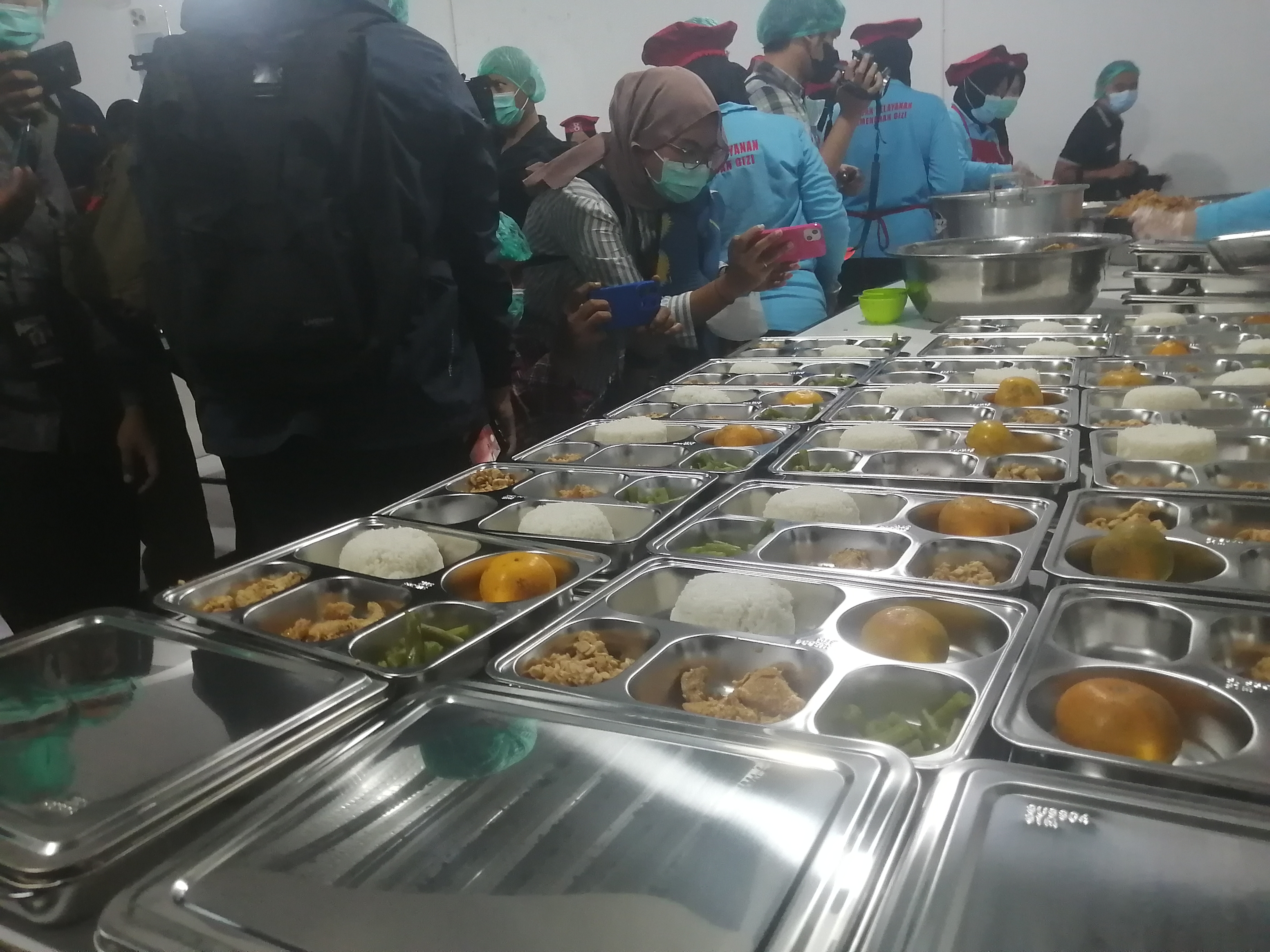 Ilustrasi petugas sedang menyiapkan menu makan bergizi gratis. (SinPo.id/Tio)