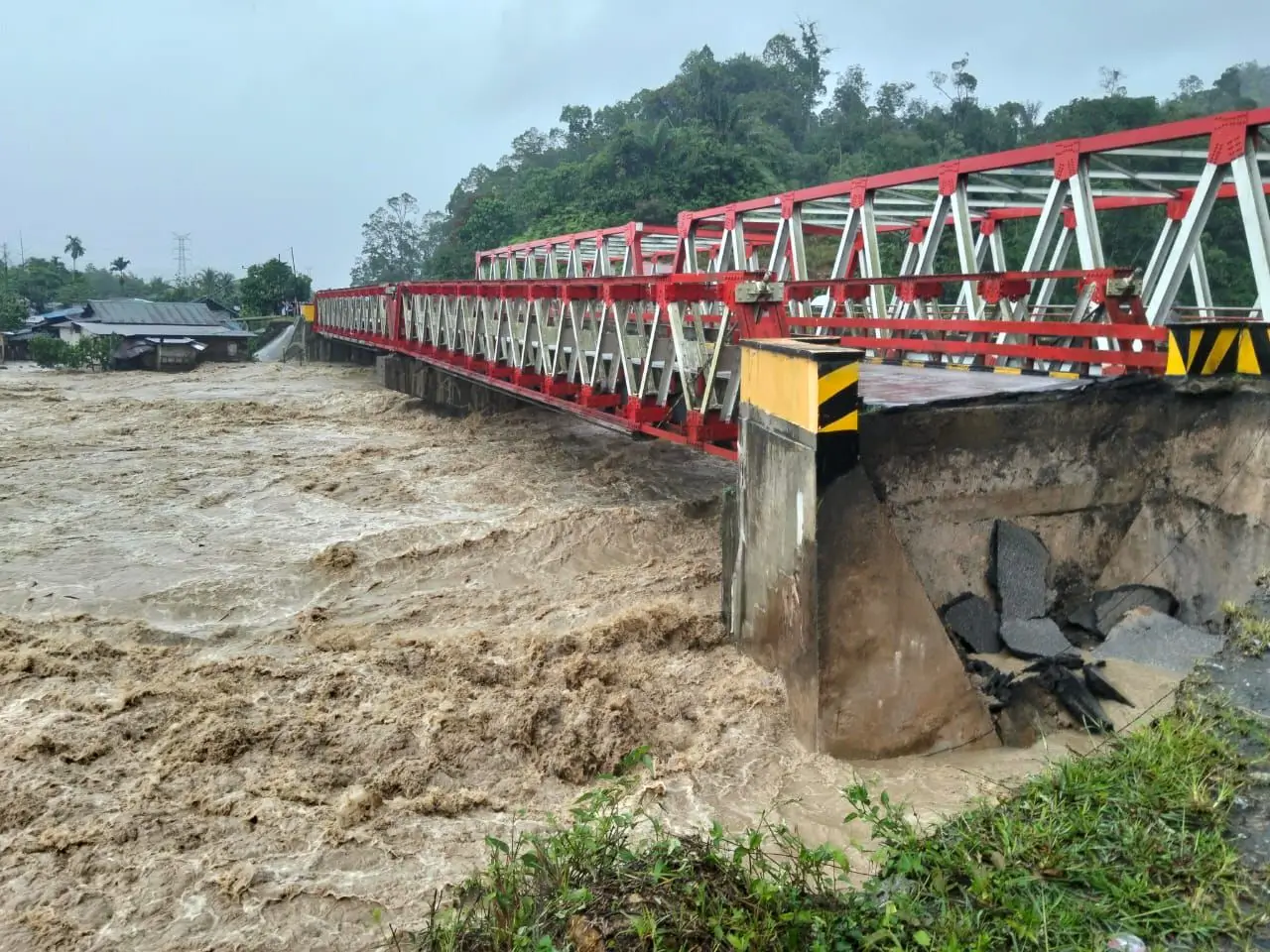Kondisi jembatan yang terputus akibat banjir di Kabupaten Tapanuli Utara, Sumatra Utara, Selasa (25/11). (SinPo.id/BPBD Kabupaten Tapanuli Utara)