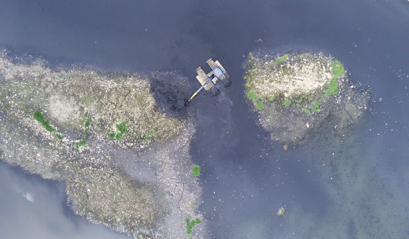 Pengerukan lumpur Waduk Pluit. (Agus Priatna/SinPo.id)