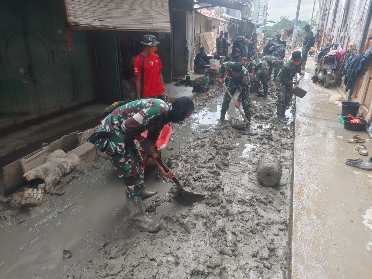 Personel TNI bersihkan lumpur di Pasar Kuala Simpang (SinPo.id/ Puspen TNI)